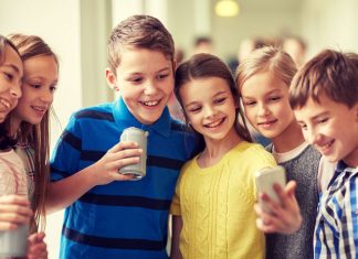 Schulkinder schauen auf ein Handy