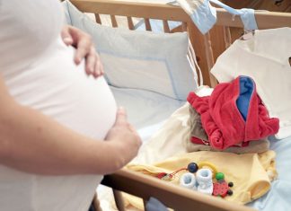 Schwangere mit Erstausstattung fürs Baby