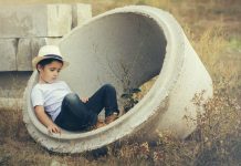 Kind sitzt in Betonreifen