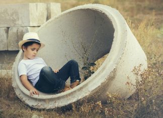 Kind sitzt in Betonreifen