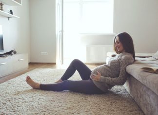 Sitzende Schwangere hält ihren Bauch