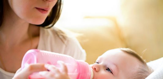 Baby trinkt aus dem Fläschchen