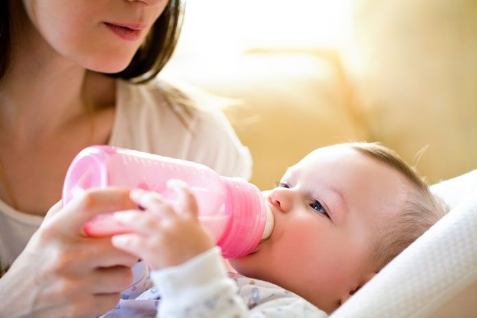 Baby trinkt aus dem Fläschchen