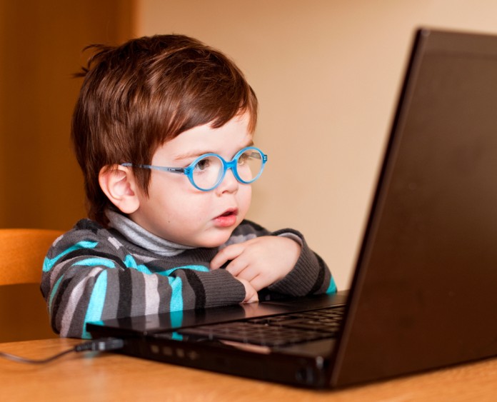 Kind sitzt vor Lerncomputer