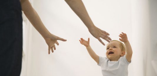 Baby streckt Hände nach Mutter aus