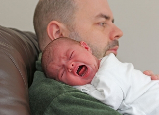 Vater hält schreiendes Baby