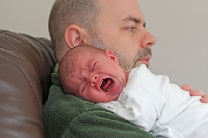 Vater hält schreiendes Baby