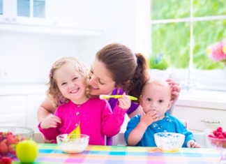 Kinder essen Brei mit Mutter