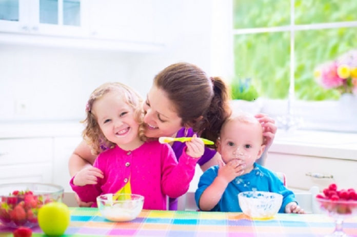 Kinder essen Brei mit Mutter