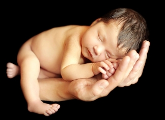 Baby auf Hand von Eltern