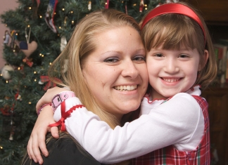 Mutter mit Kid vor dem Weihnachtsbaum