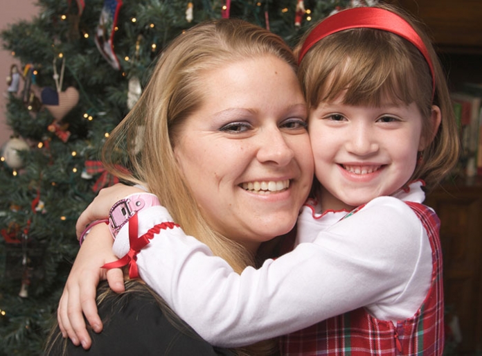 Mutter mit Kid vor dem Weihnachtsbaum