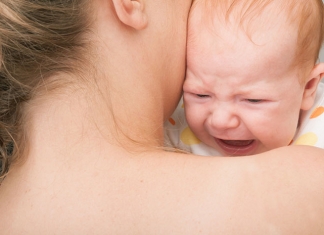 High Need Kinder: Mutter mit weinendem Baby am Arm