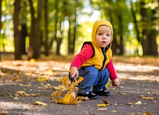 Baby sitzt im Park Herbst Krankheitsrisiko