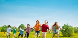 Fröhliche Kinder laufen über eine Wiese