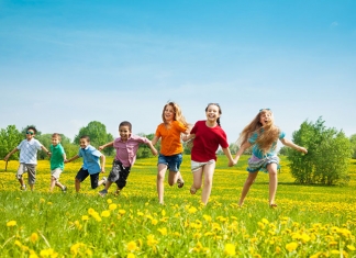 Fröhliche Kinder laufen über eine Wiese