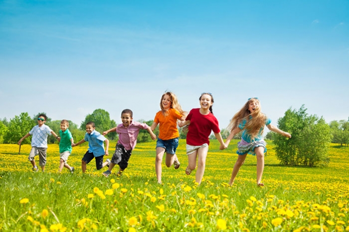 Fröhliche Kinder laufen über eine Wiese