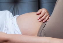 Schwangere streichelt ihren Bauch.