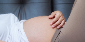 Schwangere streichelt ihren Bauch.