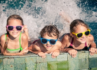 3 Kinder planschen im Wasser