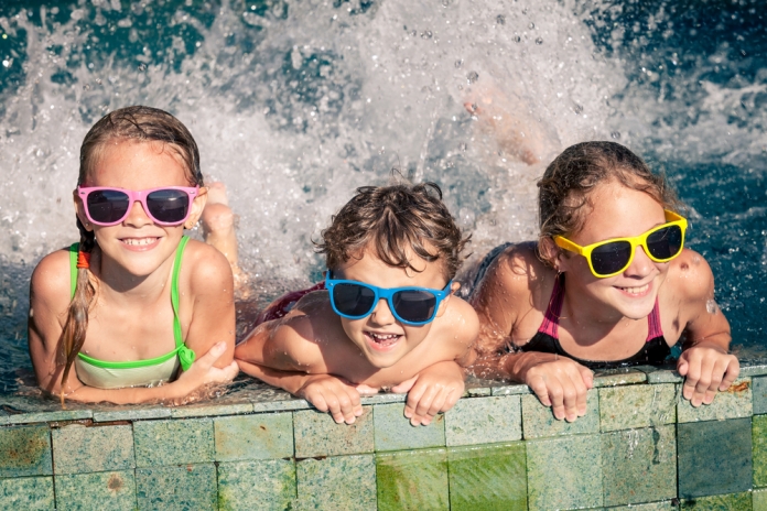 3 Kinder planschen im Wasser